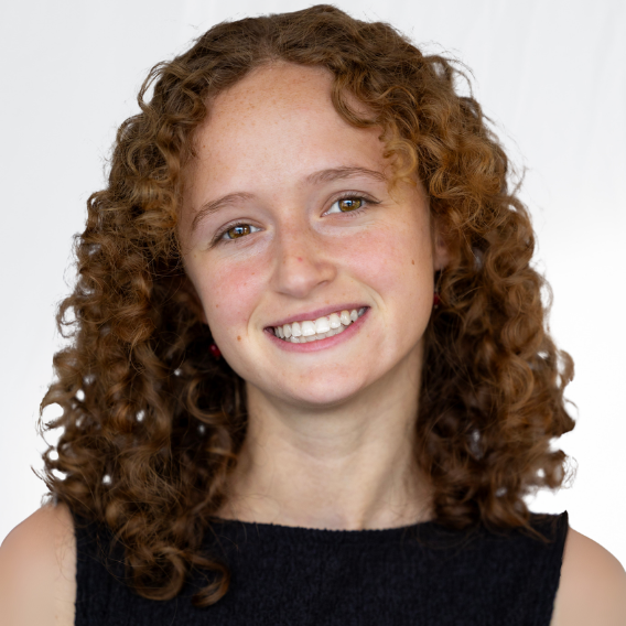 White woman with black dress smiling.