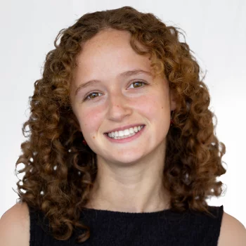 White woman with black dress smiling.
