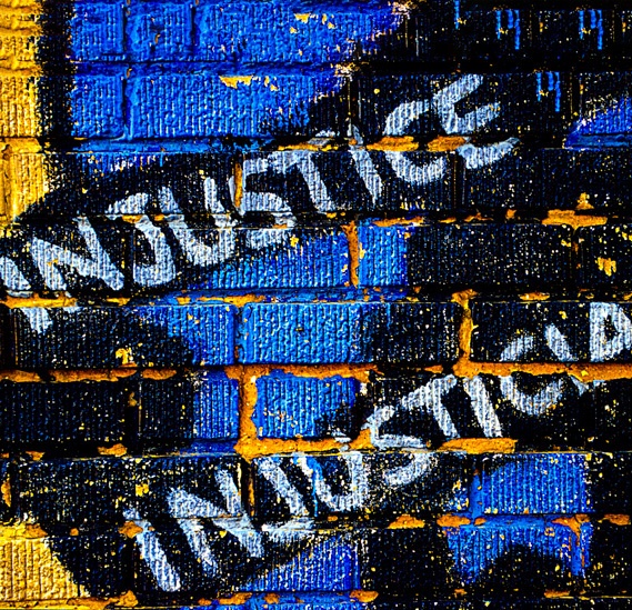 A mural saying "Injustice" and "Injusticia"