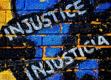 A mural saying "Injustice" and "Injusticia"