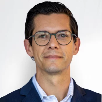 Stephen Hayes is a white man in his mid-40s with glasses. He is wearing a dark blue suit and white shirt.